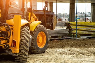 Buldozer yol kenarındaki toprak ve moloz yığınını hareket ettiriyor. İnşaat alanındaki toprak üzerinde çalışan buldozer. Yol yapım aşamasında..