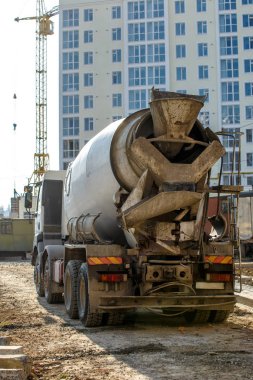 Karıştırıcı kamyon inşaat alanındaki döküm yerine çimento taşınıyor, seçici odaklanma. İnşaattaki beton karıştırıcı binanın temellerine dökülüyor.