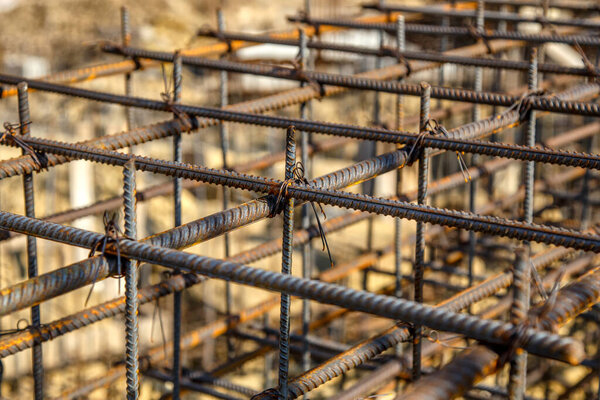 steel rebar for reinforcement concrete at construction site with house under construction background,Industrial background.Rusty rebar for concrete pouring.