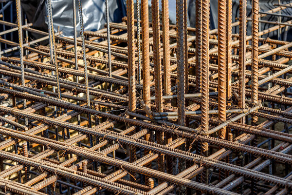 steel rebar for reinforcement concrete at construction site with house under construction background,Industrial background.Rusty rebar for concrete pouring.