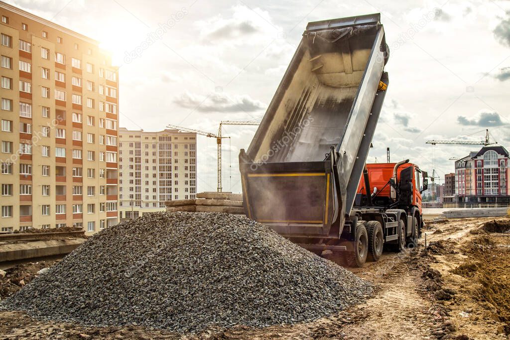 Construction truck tipping dumping gravel on road construction site,tip truck and ripper at work preparing ground for new housing estate,Dump truck unloading process,