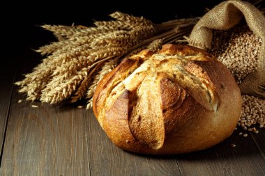 Taze pişmiş geleneksel ekmek ahşap masada, fotokopi odası ve yiyecek yakın plan. Tohumlu tam tahıllı çavdar ekmeği.