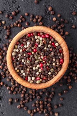 Bir biber seti. Farklı tip biber kolajı, siyah, beyaz, pembe ve tüm baharatlı biber, kurutulmuş kırmızı biber. Üst görünüm. Siyah bir arka planda. Metnin için boş yer.