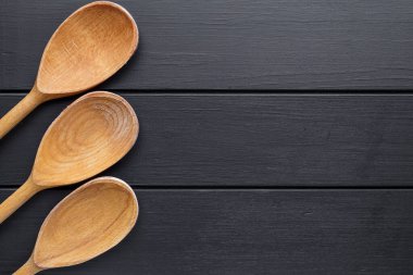 Tahta kaşıklar siyah arka planda izole edilmiş. Eski tarz. Üst görünüm, alanı kopyala.