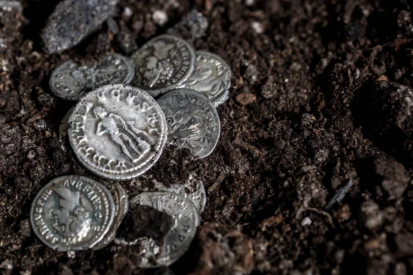 Ancient coin of the Roman Empire.Authentic silver denarius, antoninianus of ancient Rome.Roman silver coins covered in dirt.Antikvariat.