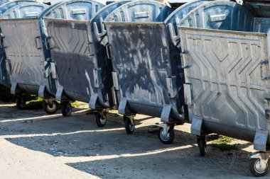 Yolun kenarında bir grup çöp tenekesi var. Atık geri dönüşümü, metal çöp tenekeleri