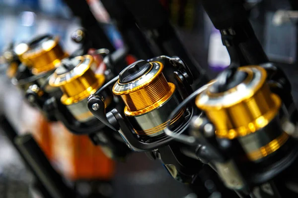 Balıkçıdaki tezgahın üzerinde farklı boyutlarda makaralar var. Yüzeyin sığ derinliği, bir balık oltasına yakın çekim