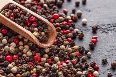 Bir biber seti. Farklı tip biber kolajı, siyah, beyaz, pembe ve tüm baharatlı biber, kurutulmuş kırmızı biber. Üst görünüm. Siyah bir arka planda. Metnin için boş yer.