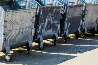 Yolun kenarında bir grup çöp tenekesi var. Atık geri dönüşümü, metal çöp tenekeleri