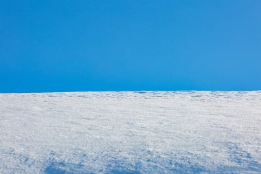 Mavi gökyüzünün arka planında kar yağışı desenleri.