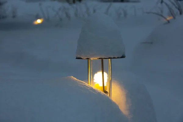 Elektromos fáklya világítja meg a kertet nehéz hóesések idején.. — Stock Fotó
