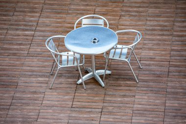 Kahverengi zemine karşı bir masa ve üç sandalye. Terk edilmiş kaplıca