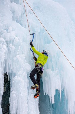 Kış buz tırmanışı duvarında antrenman yapan sporcular.