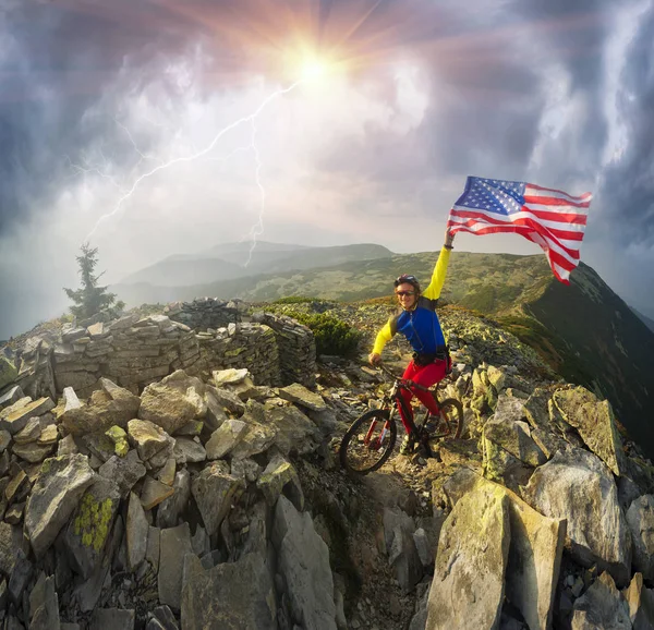 Ποδηλάτης με σημαία των ΗΠΑ στα βουνά — Φωτογραφία Αρχείου