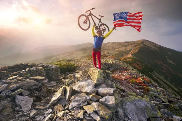 Велосипедист з прапором США в горах — стокове фото