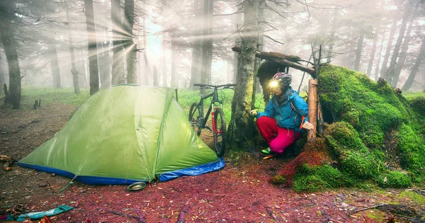 Ciclista se prepara para passar a noite em uma tenda — Fotografia de Stock