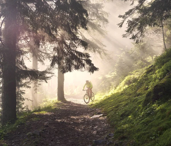 Homem de bicicleta em montanhas com raios de sol — Fotografia de Stock