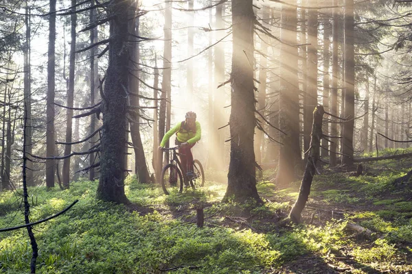 Чоловік їздить на велосипеді в горах з сонячними променями — стокове фото