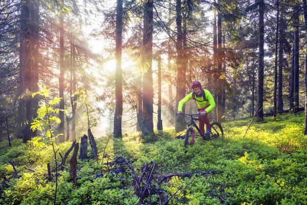 Ο άνθρωπος ποδηλασία ποδήλατο στα βουνά με ηλιόλουστες ακτίνες — Φωτογραφία Αρχείου
