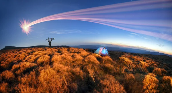 Cyclist at sunrise and tents — Stock Photo, Image