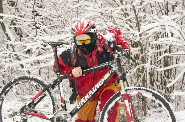 Een man loopt op fiets in sneeuwval — Stockfoto