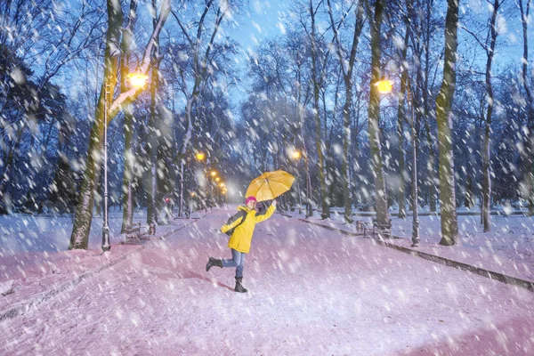 Chica con paraguas amarillo en el parque de invierno —  Fotos de Stock
