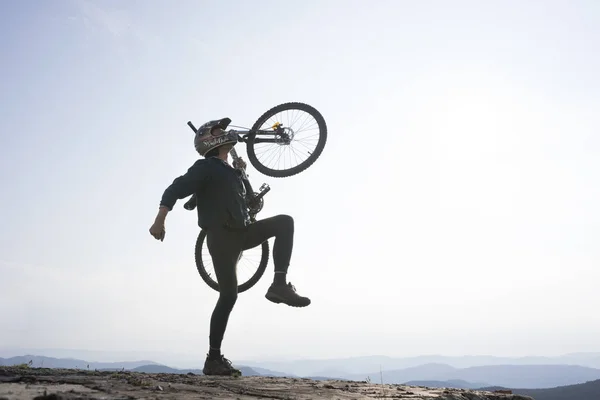 Silhouet van de renner met fiets — Stockfoto