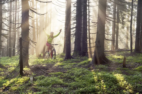 Ο άνθρωπος ποδηλασία ποδήλατο στα βουνά με ηλιόλουστες ακτίνες — Φωτογραφία Αρχείου