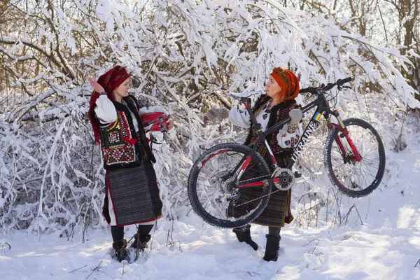 Meisjes in klederdracht met fiets in de winter — Stockfoto