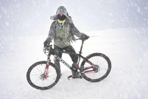 Ταξίδι με ένα ποδήλατο βουνού σε μια καταιγίδα χιόνι — Φωτογραφία Αρχείου