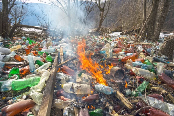 游客拍摄了生态灾难的全景 这条河把塑料垃圾带到欧洲 被非文化人群抛弃 塑胶火释放危险化学品 — 图库照片