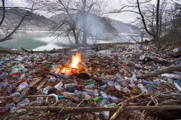 游客拍摄了生态灾难的全景 这条河把塑料垃圾带到欧洲 被非文化人群抛弃 塑胶火释放危险化学品 — 图库照片