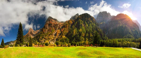 Swiss valley among the picturesque autumn peaks of the Alps. Beautiful houses, smooth roads create a romantic image of comfort and ecology