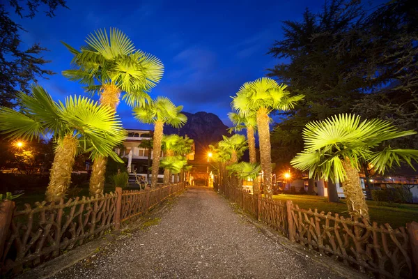 意大利的科莫湖谷位于日落时分阿尔卑斯山的晚峰之间 美丽的房子 热带棕榈树营造出一种浪漫的舒适的形象 — 图库照片
