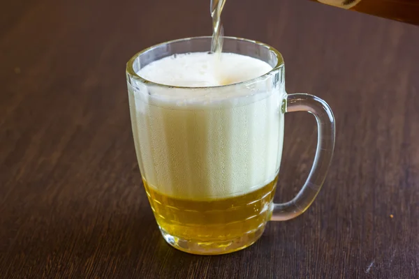 Bier aus Flasche in Becher an Bar gießen — Stockfoto