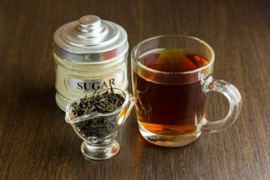 ahşap masa üzerinde siyah çay Kupası ve şeker kase