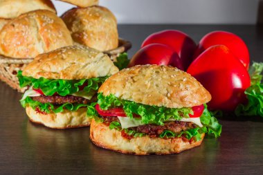 Ev yapımı hamburgerler ahşap masada.