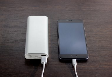 Tahtada elektrik bankasıyla çalışan akıllı telefon.