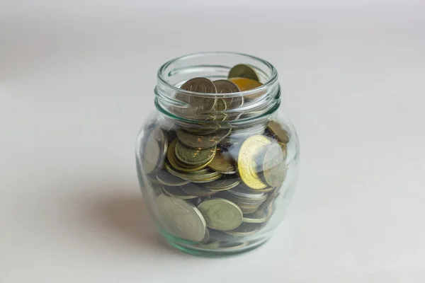 Business, financiën, investeringen, geld besparen - munten in glazen pot op tafel — Stockfoto