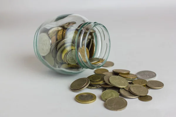 Business, financiën, investeringen, geld besparen - munten in glazen pot op tafel — Stockfoto