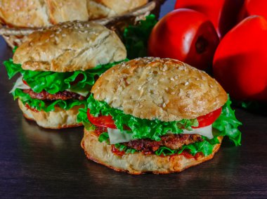 Ev yapımı hamburgerler ahşap masada.