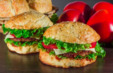 Ev yapımı hamburgerler ahşap masada.