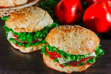 Ev yapımı hamburgerler ahşap masada.