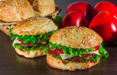 Ev yapımı hamburgerler ahşap masada.