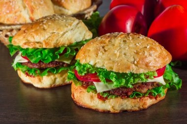 Ev yapımı hamburgerler ahşap masada.