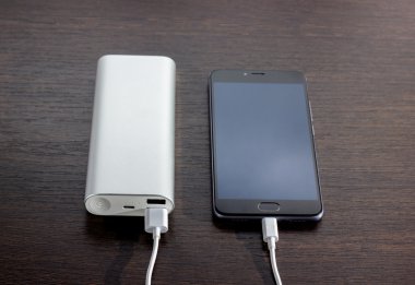 Tahtada elektrik bankasıyla çalışan akıllı telefon.