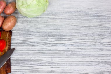 Bıçak Beyaz ahşap arka plan Üstten Görünüm noktası ile çeşitli taze sebze.