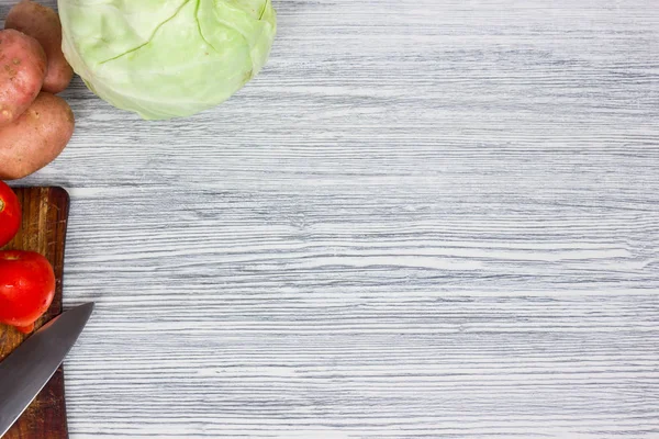 Bıçak Beyaz ahşap arka plan Üstten Görünüm noktası ile çeşitli taze sebze.