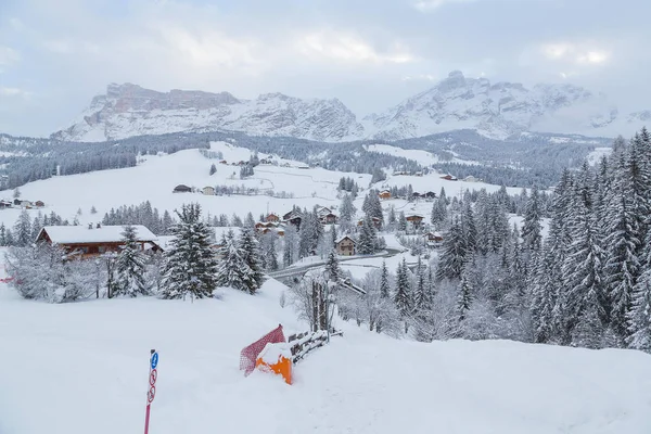 Величественный зимний пейзаж и горнолыжный курорт с типичными деревянными домами в итальянских Альпах — стоковое фото