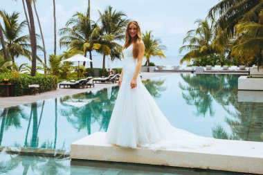 Güzel gelin bir seksi gelinlik havuzun yanında ayakta